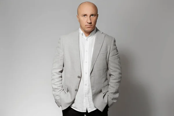 Bald man in jacket on grey background — Stock Photo, Image