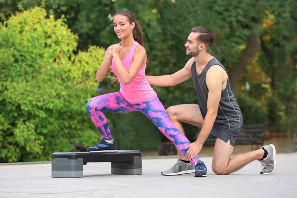 Genç kadın spor zemin üzerinde kişisel antrenör ile egzersiz — Stok fotoğraf