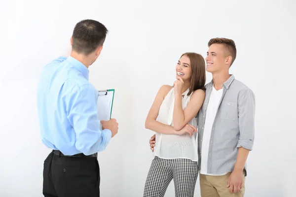 Glückliche Familie mit Immobilienmakler auf weißem Hintergrund — Stockfoto