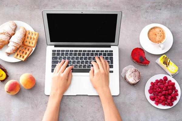 Hands of food blogger with laptop and different products on table — Stock Photo, Image