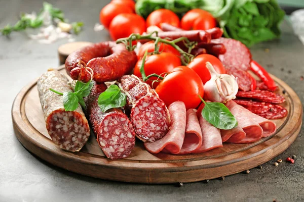 Deliciosas salchichas en rodajas con verduras sobre tabla de madera — Foto de Stock