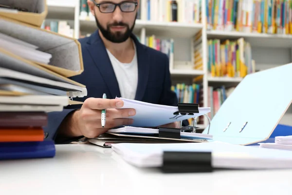 Uomo che lavora con documenti a tavola in archivio — Foto Stock