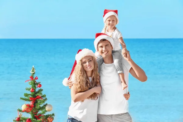 Família feliz e árvore de Natal na praia — Fotografia de Stock