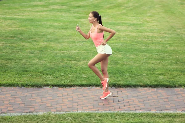 Parkta çalıştıran sportif genç kadın — Stok fotoğraf