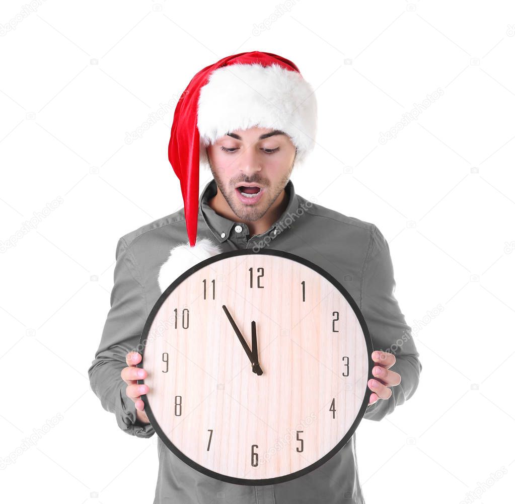 Young man in Santa hat with clock on white background. Christmas countdown concept