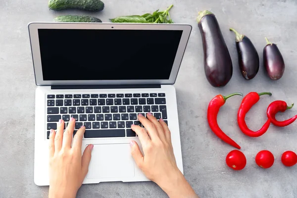 Mãos de blogueiro de comida com laptop e diferentes produtos na mesa — Fotografia de Stock