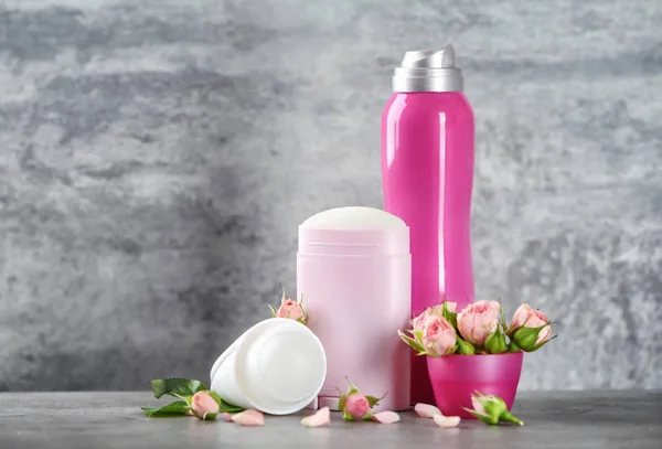 Дезодоранти для жінок і квіти на столі — стокове фото
