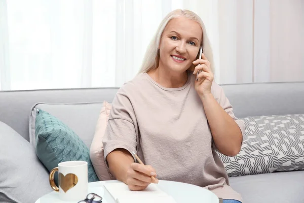 Vezető nő beszél a mobiltelefonján otthon — Stock Fotó