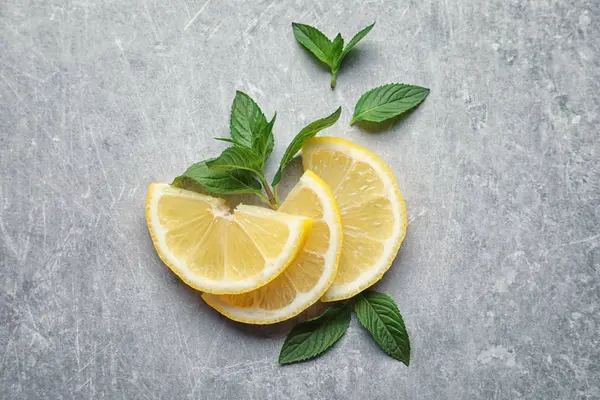 Munt en citroen op grijze achtergrond — Stockfoto