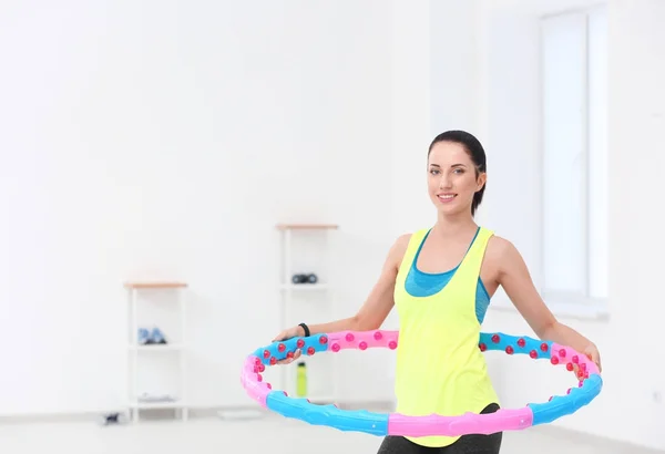 Mujer haciendo ejercicios con hula hoop en el gimnasio —  Fotos de Stock