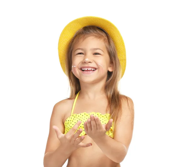 Adorável menina aplicando protetor solar sobre a pele contra fundo branco — Fotografia de Stock