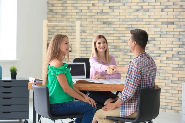 Emlak komisyoncusu ve Office yeni düz satın alma tartışırken müşteriler — Stok fotoğraf