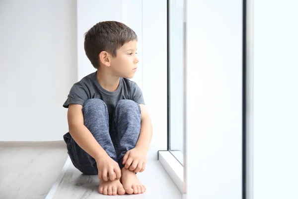 창턱에 앉아 작은 소년. 가정 폭력의 개념 — 스톡 사진