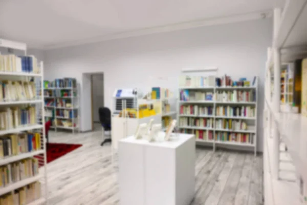 Scaffali con libri in biblioteca moderna, sfondo sfocato — Foto Stock