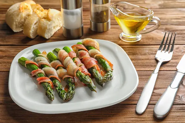 Piatto con asparagi avvolti nella pancetta — Foto Stock