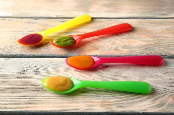 Cucharas de plástico con comida para bebés — Foto de Stock