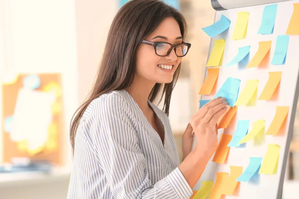 Ung affärskvinna samla idéer om fästisar i office — Stockfoto