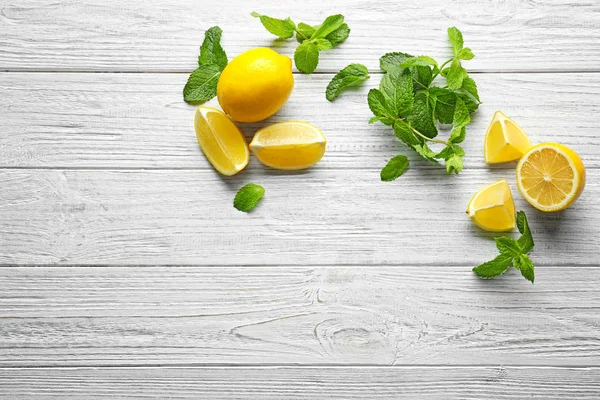 Mint and lemon on wooden background — Stock Photo, Image