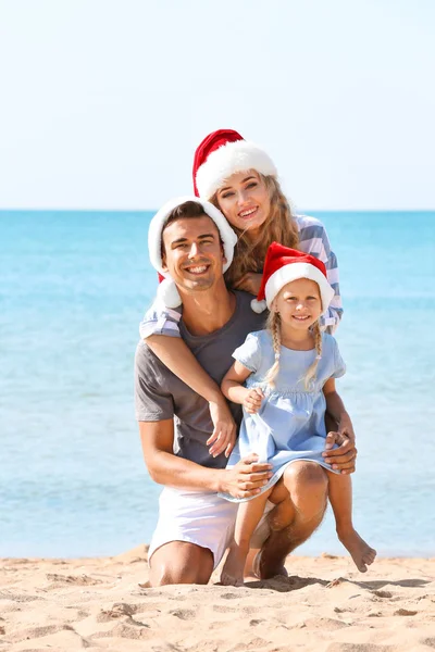 Young couple with cute girl on beach. Christmas celebration concept — Stock Photo, Image