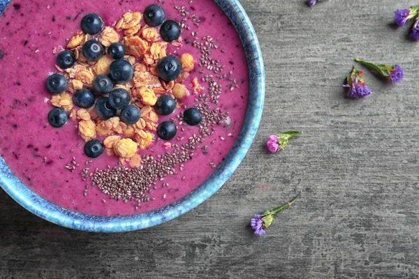 Acai güler yüzlü, çilek ve gri arka plan üzerine müsli kase