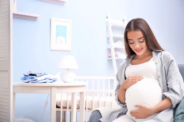 Hamile kadın bebeğin odasında oturuyordu — Stok fotoğraf