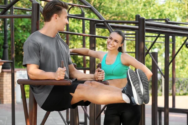 Joven pareja deportiva haciendo ejercicio en el patio de recreo —  Fotos de Stock
