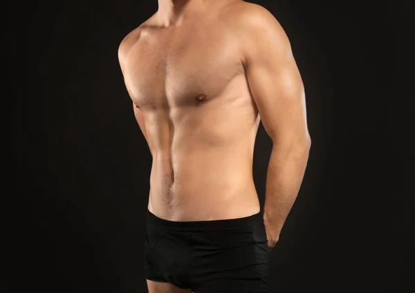 Junger Mann in Unterwäsche auf schwarzem Hintergrund — Stockfoto