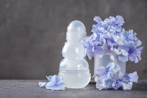 Дезодоранты для женщин и цветы на столе — стоковое фото