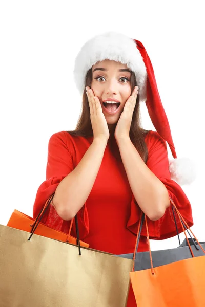 Fiatal nő Santa kalap tartó színes bevásárló táskák, fehér háttér. Boxing day koncepció — Stock Fotó