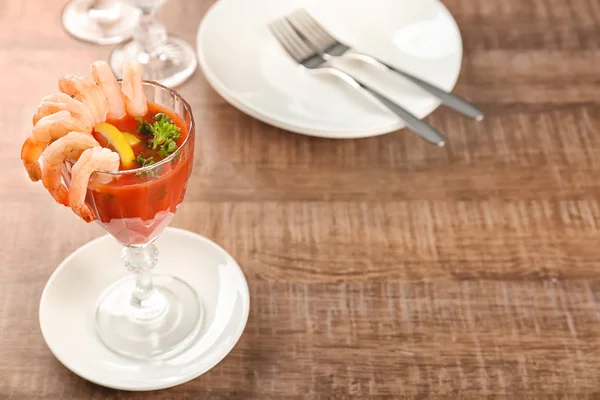 Copo com coquetel de camarão e molho de tomate na mesa de madeira — Fotografia de Stock
