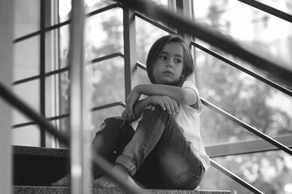 Dziewczynka, siedząc na schodach w pomieszczeniu. Pojęcie przemocy w rodzinie — Zdjęcie stockowe