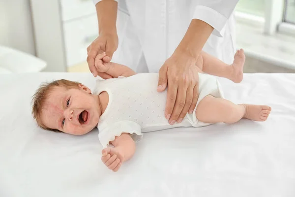 Adorable bebé con alergia a la piel acostado en la mesa en el hospital —  Fotos de Stock