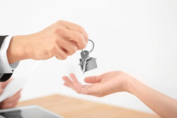 Agente inmobiliario dando la llave a la mujer en la oficina —  Fotos de Stock