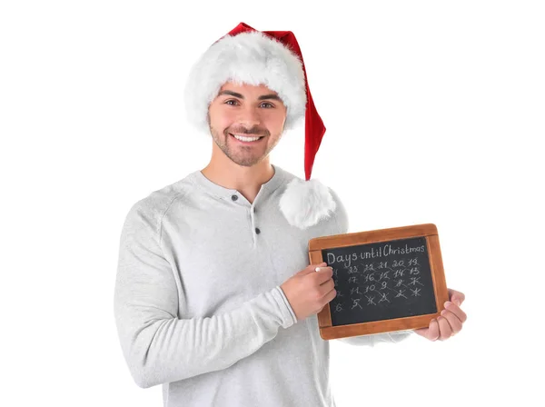 Jeune homme au chapeau de Père Noël avec des jours de comptage tableau jusqu'à Noël, sur fond blanc — Photo