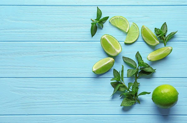 Composition with lime and mint on color wooden background — Stock Photo, Image
