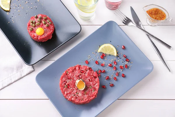 Platos con deliciosos filetes tartare en la mesa —  Fotos de Stock