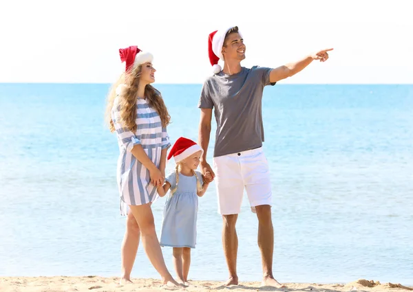 Pareja joven con linda chica en la playa. Concepto de celebración de Navidad —  Fotos de Stock