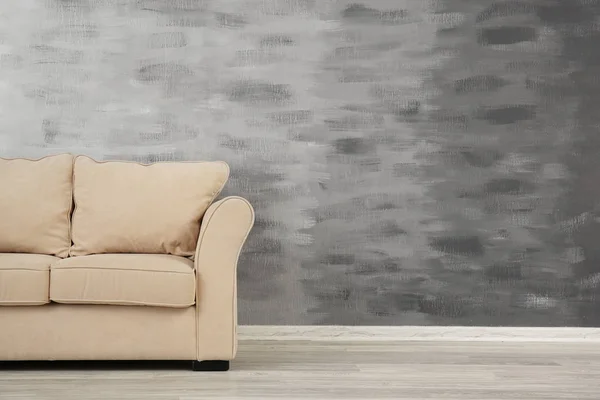 Gemütliches Sofa auf Grunge-Wand-Hintergrund — Stockfoto