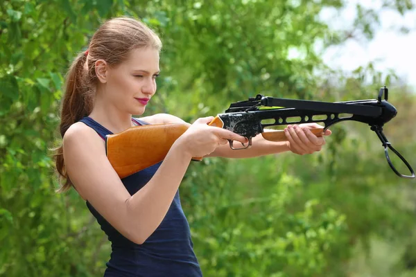 Молодая женщина стреляет из арбалета — стоковое фото