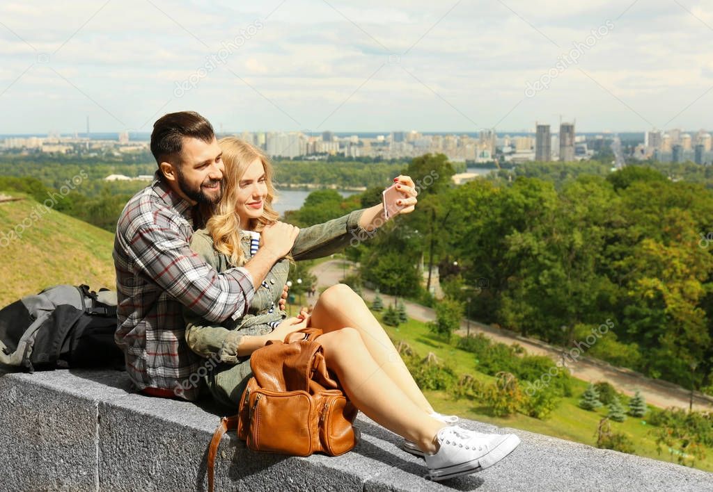 Happy young tourists taking selfie outdoors