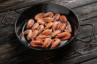 Ahşap masa üzerinde karides ile kızartma tavası