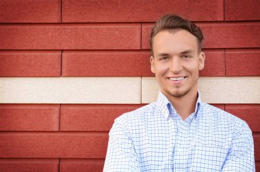 Tuğla duvar arka plan üzerinde genç adam