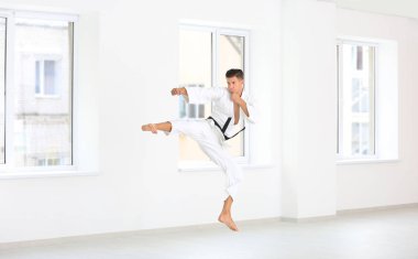 Male karate instructor training in dojo clipart