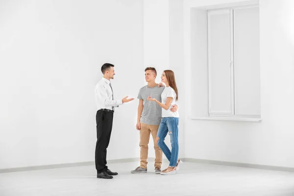 Familia feliz con agente inmobiliario en la luz nuevo apartamento — Foto de Stock