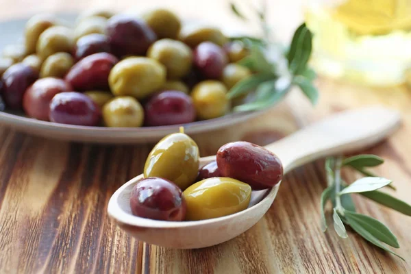 Cuchara con aceitunas enlatadas en la mesa —  Fotos de Stock