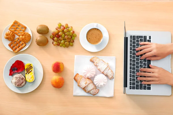 ノート パソコンとテーブルの上の異なる製品と食品のブロガーの手 — ストック写真