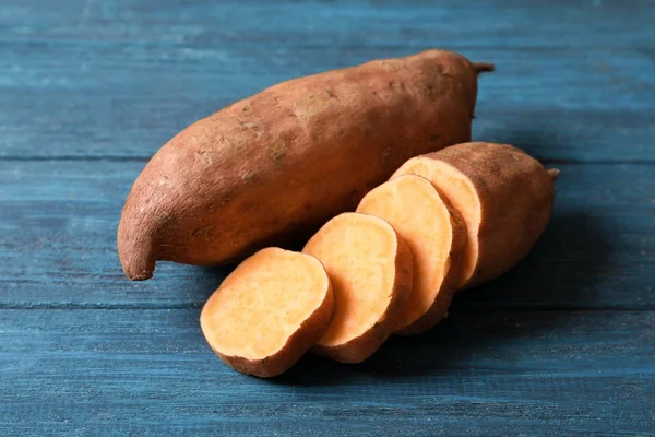 Sweet potatoes on wooden background — Stock Photo, Image