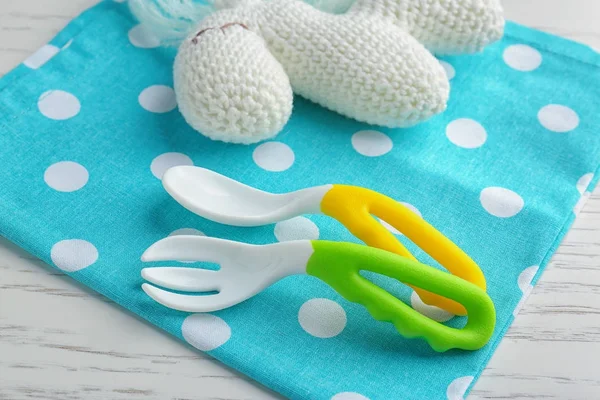 Colorful plastic eating utensils for baby on table — Stock Photo, Image