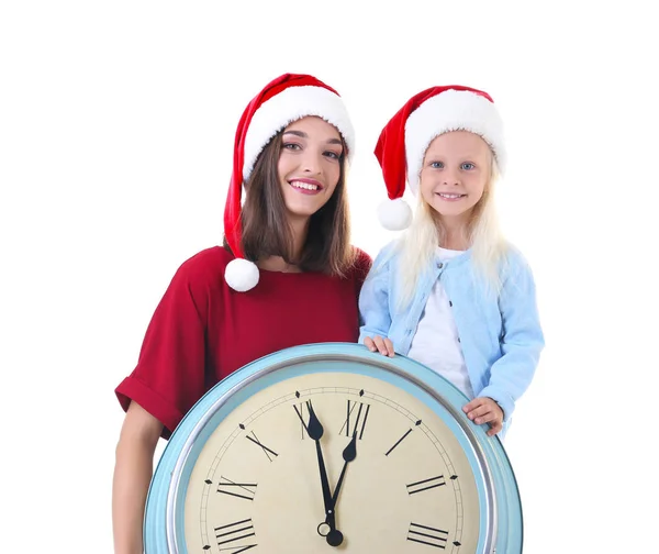 젊은 여자와 흰색 바탕에 시계와 산타 모자에 귀여운 소녀. 크리스마스 카운트다운 개념 — 스톡 사진
