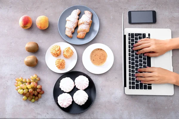 Händerna på matbloggare med laptop och olika produkter på bord — Stockfoto